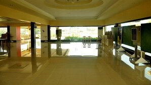 A spacious lobby with a high ceiling, a chandelier, and a view of the outdoors.
