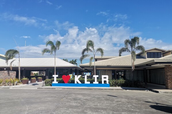 A building with a sign that reads "I ♥ KLIR" and a covered parking area. - Klir Waterpark Resort (Plaridel)