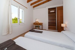 A bedroom with two beds, a desk, a chair, and a wardrobe. - Sea Frontline House With 180 Degree Panoramic Sea Views (Es Mercadal)