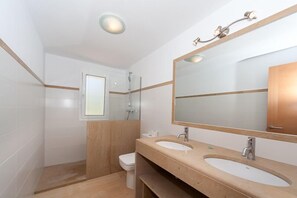 A modern bathroom with two sinks, a large mirror, and a shower. - Sea Frontline House With 180 Degree Panoramic Sea Views (Es Mercadal)