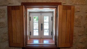 A wooden-framed window with two glass panes, set in a stone wall. - Casa do Pioledo (Camélias de Basto-Turismo Rural) (Celorico de Basto)