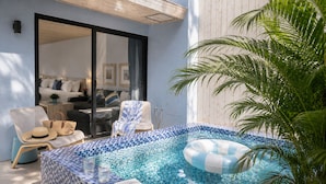 A private pool area with a tiled floor, lounge chairs, a floating ring, and a potted plant. - Azure Inn (Hengchun)
