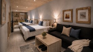 A modern hotel room with two beds, a sofa, a coffee table, and framed artwork on the walls. - Azure Inn (Hengchun)