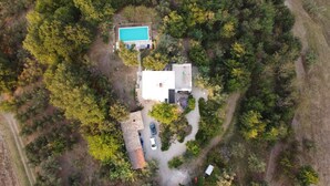 Vista aérea de una propiedad residencial con piscina, garaje independiente y entrada para vehículos.