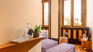Ein modernes Zimmer mit einem Holztisch, einer Topfpflanze, einem Glas Wasser und einem Fernseher.