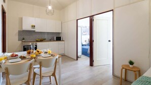 Una cucina moderna con mobili bianchi, un tavolo da pranzo con sedie e angolo colazione.
