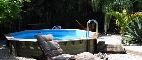 Una piscina con una tumbona y una hamaca.