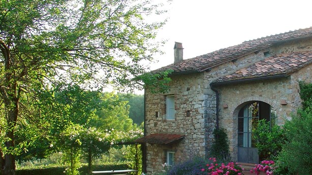 A stone house with a tiled roof, a small porch, and a garden with flowers and shrubs. - House with pool. Idyllic setting in hills near Lucca and coast WiFi Aircon       (Torcigliano)