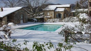 A stone house with a swimming pool surrounded by snow-covered ground and trees. - House with pool. Idyllic setting in hills near Lucca and coast WiFi Aircon       (Torcigliano)