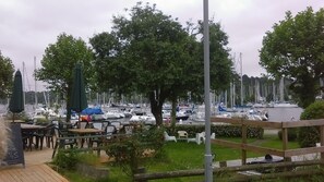 A marina with numerous boats docked, surrounded by trees and a wooden deck with outdoor seating. - Charming cottage with enclosed garden in peaceful countryside. Pet welcome. (Béganne)