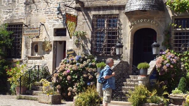 Ein Steinhaus mit einem Schild, auf dem 'Antiquaire' steht.