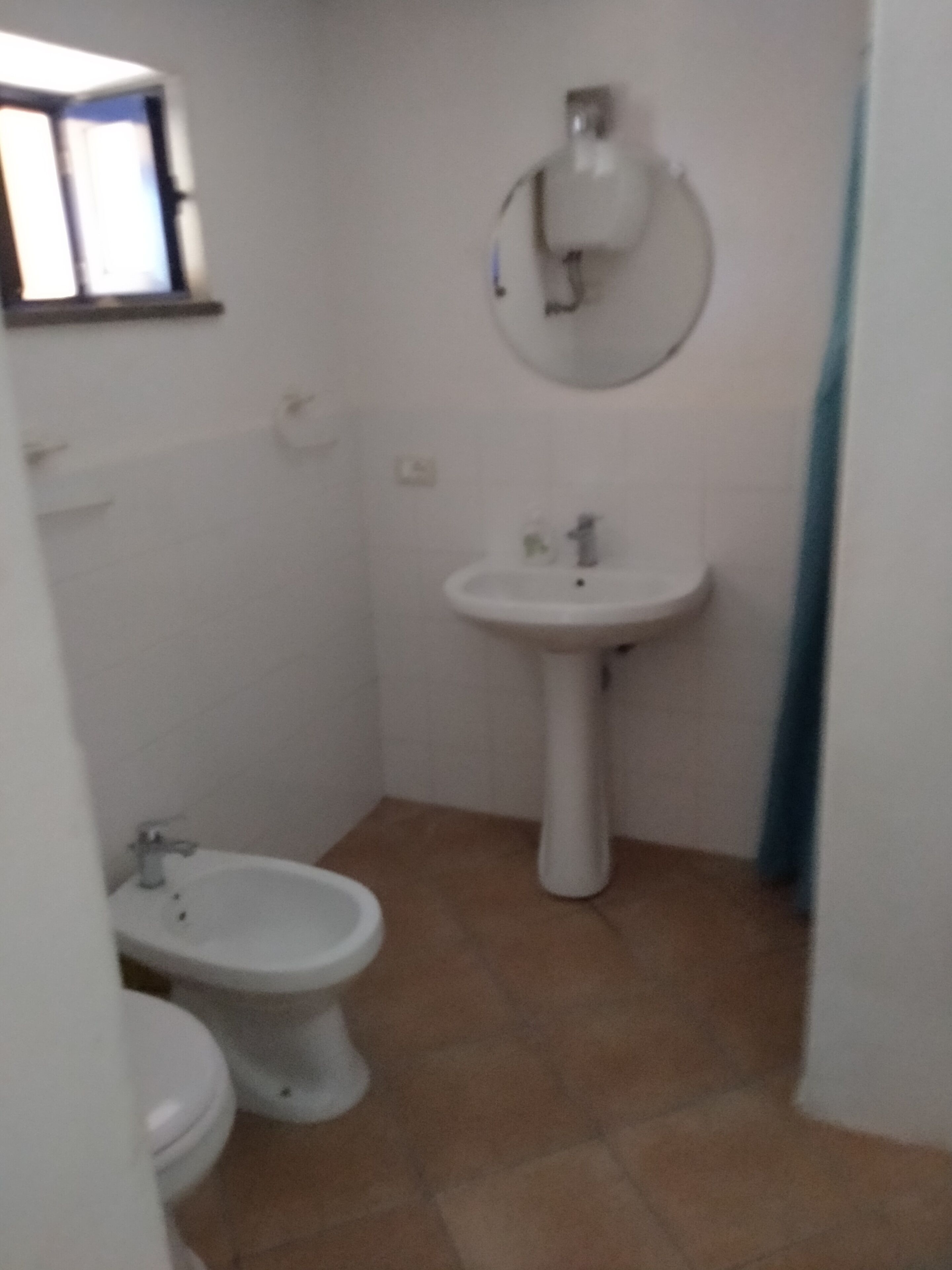 A small bathroom with a toilet, bidet, and sink.