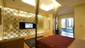 A bedroom with a TV, a bed, a large window, and a patterned wall. - Fortune Villa Motel (New Taipei City)