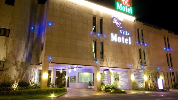 A motel with a neon sign, a covered entrance, and well-lit exterior. - Fortune Villa Motel (New Taipei City)