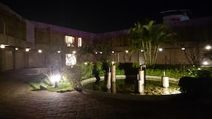 A courtyard with a paved walkway, a small water feature, and several cylindrical planters with candles. - Fortune Villa Motel (New Taipei City)