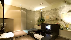 A modern bathroom with a bathtub, shower, and a digital screen. - Fortune Villa Motel (New Taipei City)