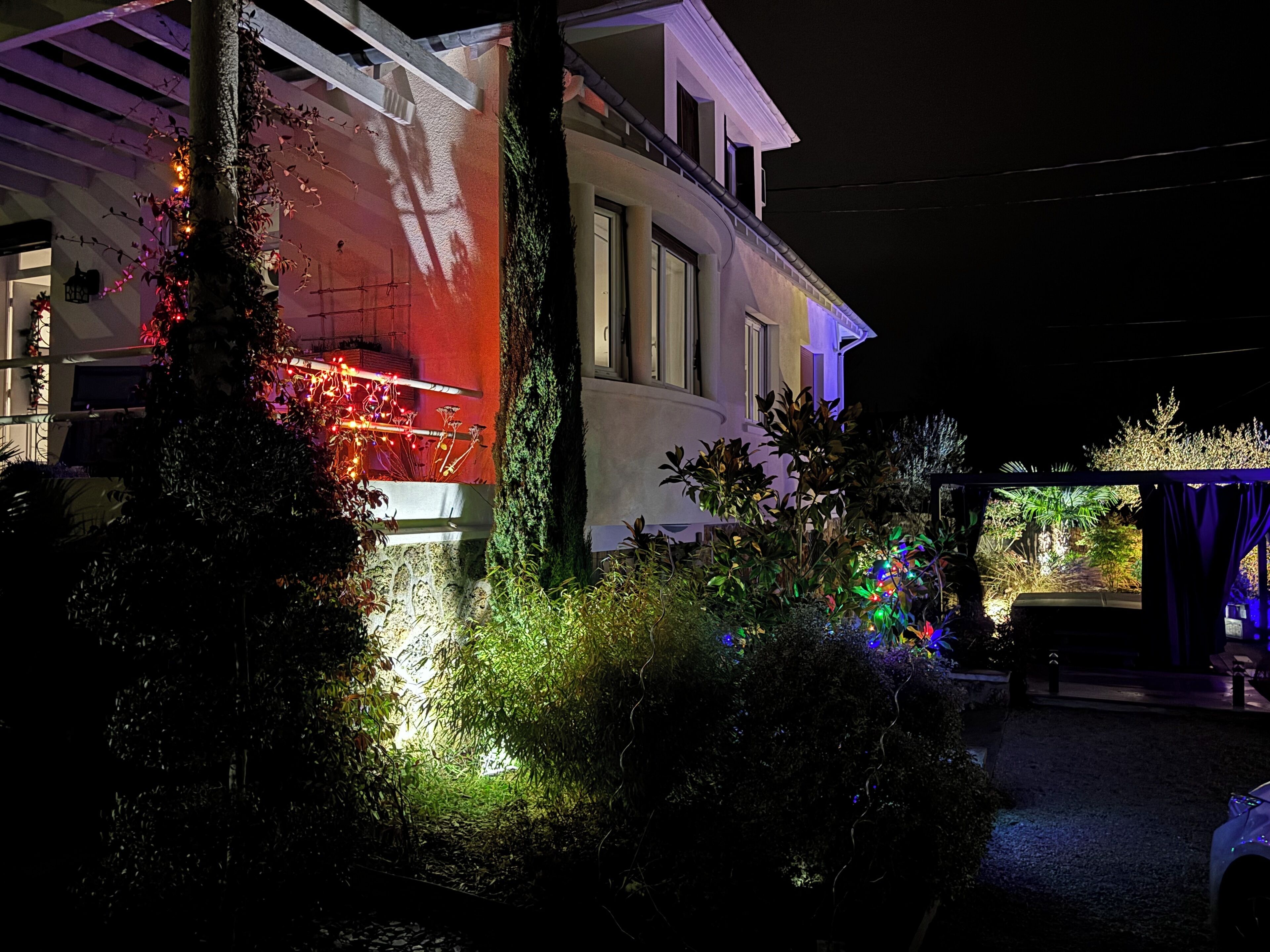 Una casa con giardino, una pergola e un vialetto.