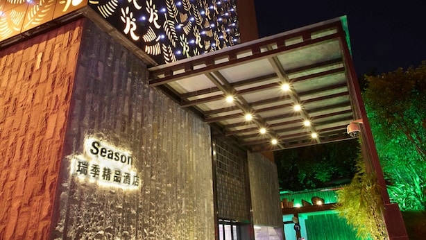 Fachada de edificio con un letrero que dice "Season" y una zona de entrada cubierta.