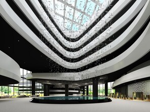 A modern atrium with a central pool, multiple levels, and a glass ceiling. - LN Garden Hotel Nansha Guangzhou (Guangzhou)