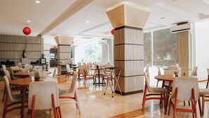 A spacious hotel lobby with multiple seating areas, a central column with a geometric pattern, and large windows providing natural light. - Ascent Premiere Pasuruan (Pasuruan)