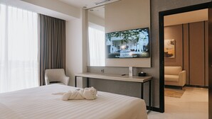 A hotel room with a bed, a desk, a television, and a chair. - Ascent Premiere Pasuruan (Pasuruan)