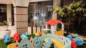 A children's play area with a slide, climbing structures, and a small house. - Ascent Premiere Pasuruan (Pasuruan)