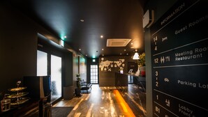 A hotel lobby with a wooden floor, a reception desk, and a world map on the wall. - Hotel AMARE (Suwon)