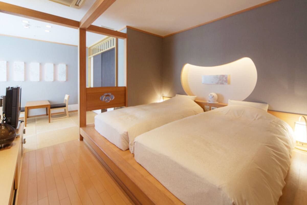 A hotel room with a wooden bed, a desk, and a chair.