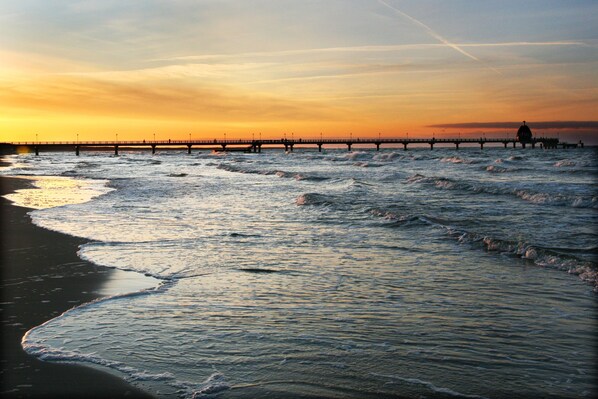 A pier extending into the water with waves lapping at the shore. - Damerow Dünenstraße - Holiday apartment (Zinnowitz)