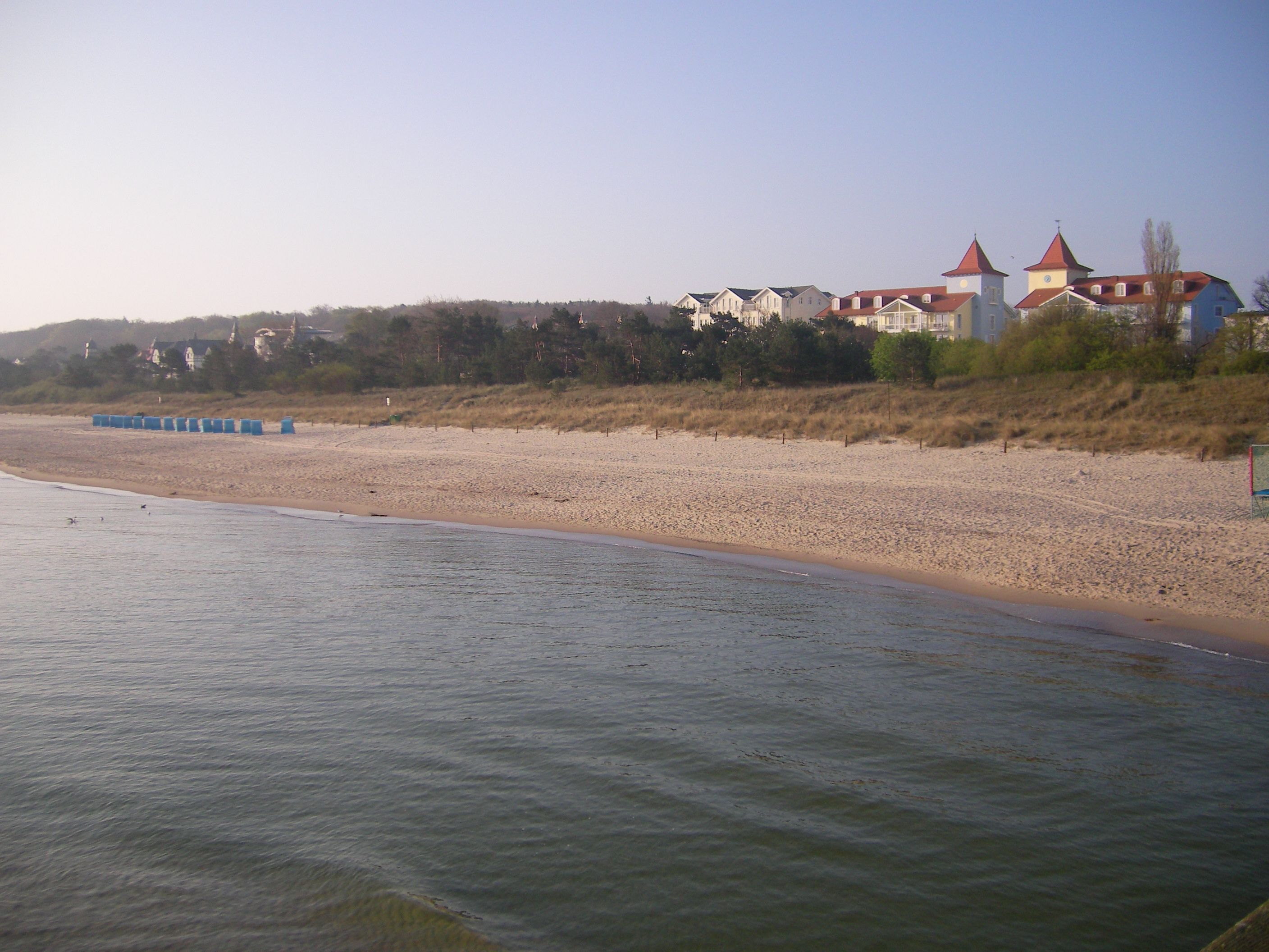 Ein Strand mit einer Reihe von Gebäuden im Hintergrund.