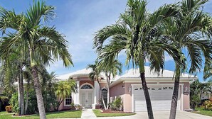 A residential house with a garage, palm trees, and a well-maintained lawn. - Fantastic villa with an fantastic view in a quiet location - Villa Wonderview (Cape Coral)