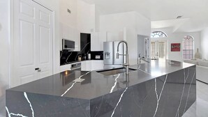 A modern kitchen with a large island, white cabinetry, and stainless steel appliances. - Fantastic villa with an fantastic view in a quiet location - Villa Wonderview (Cape Coral)