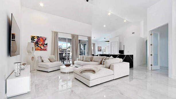 A spacious living room with a large sectional sofa, a coffee table, and a flat-screen TV mounted on the wall. - Fantastic villa with an fantastic view in a quiet location - Villa Wonderview (Cape Coral)