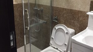 A modern bathroom with a glass-enclosed shower, a white toilet, and a towel rack. - Umali Kayo at Megatower Residences 1 (Baguio)