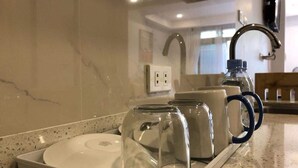 A kitchen counter with a tray holding a plate, a glass jar, and a mug. - Umali Kayo at Megatower Residences 1 (Baguio)