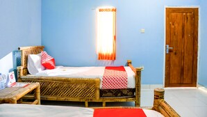 Una habitación con una cama individual, una puerta de madera y una ventana con cortinas.