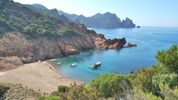 A coastal landscape with rocky cliffs, a sandy beach, and boats anchored near the shore. - SEASIDE APARTMENT WITH HEATED POOL (Galéria)