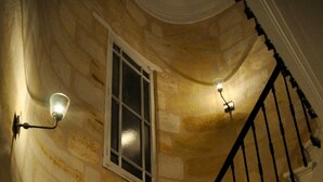 Una escalera de caracol con paredes de piedra e iluminación empotrada.