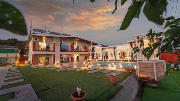 A two-story building with a balcony, a swimming pool, and a well-maintained lawn. - Treebo Winter Town Venna Lake (Mahabaleshwar)