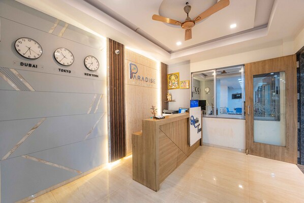 A reception area with clocks displaying times for Dubai, Tokyo, and New York.