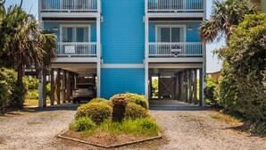 Un edificio de dos pisos con fachada azul y balcones blancos.