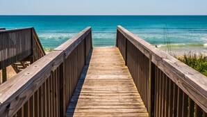 Una pasarela de madera que conduce al océano, con una vista despejada del mar.
