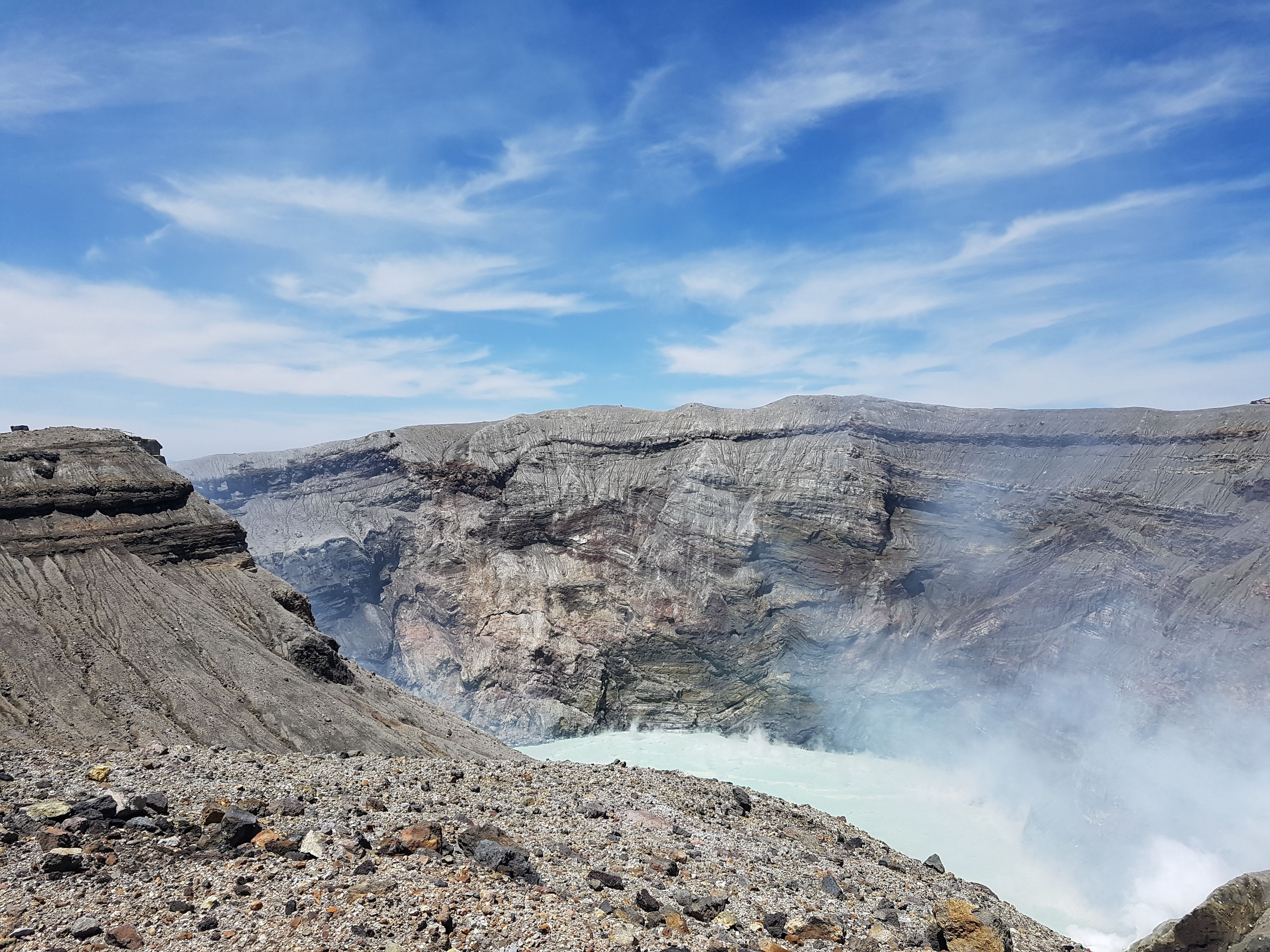 Paisagem acidentada com terreno rochoso e um rio serpenteando por um cânion.