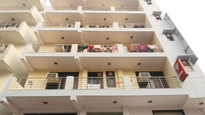A multi-story building with balconies, air conditioning units, and a visible sign. - JKM Palace (New Delhi)