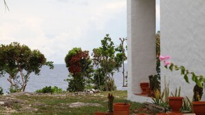 Un jardín con macetas de terracota y vistas al mar.