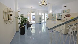 A spacious lobby with a chandelier, potted plants, and a reception desk. - Hotel da Ettore (Porto Cesareo)