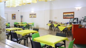 A dining area with multiple tables and chairs, some covered with yellow tablecloths. - Hotel da Ettore (Porto Cesareo)