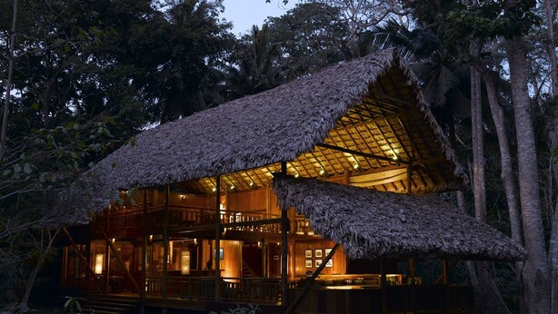 A wooden cabin with a thatched roof, surrounded by trees. - Barefoot at Havelock (Port Blair)