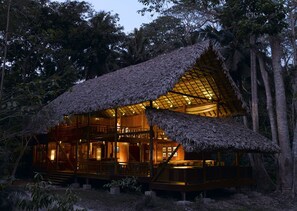 A wooden cabin with a thatched roof, surrounded by trees. - Barefoot at Havelock (Port Blair)