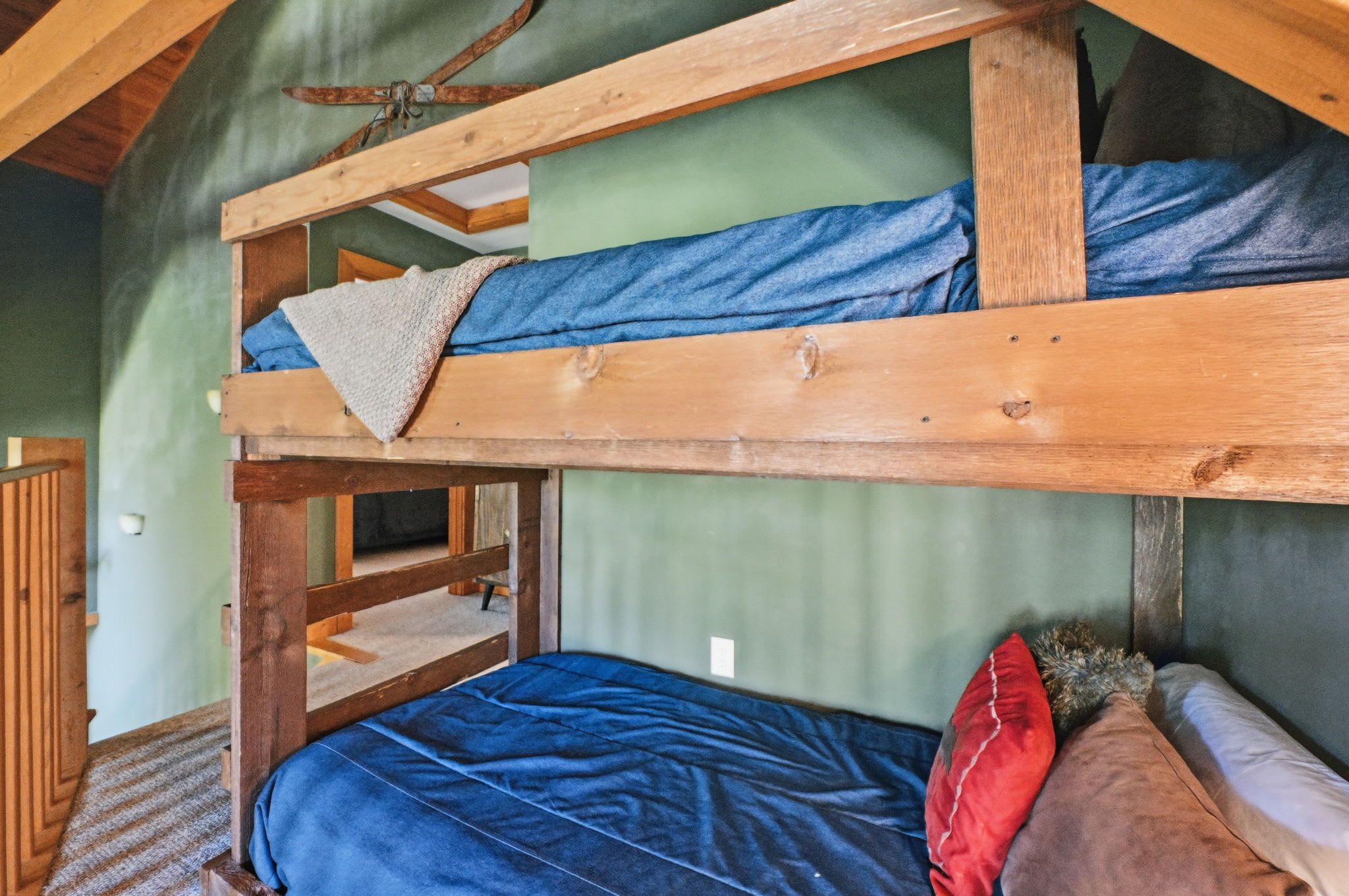 A bunk bed with a wooden frame and a blue mattress.